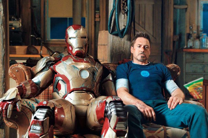 Tony Stark sits next to his Iron Man suit in Iron Man 3.