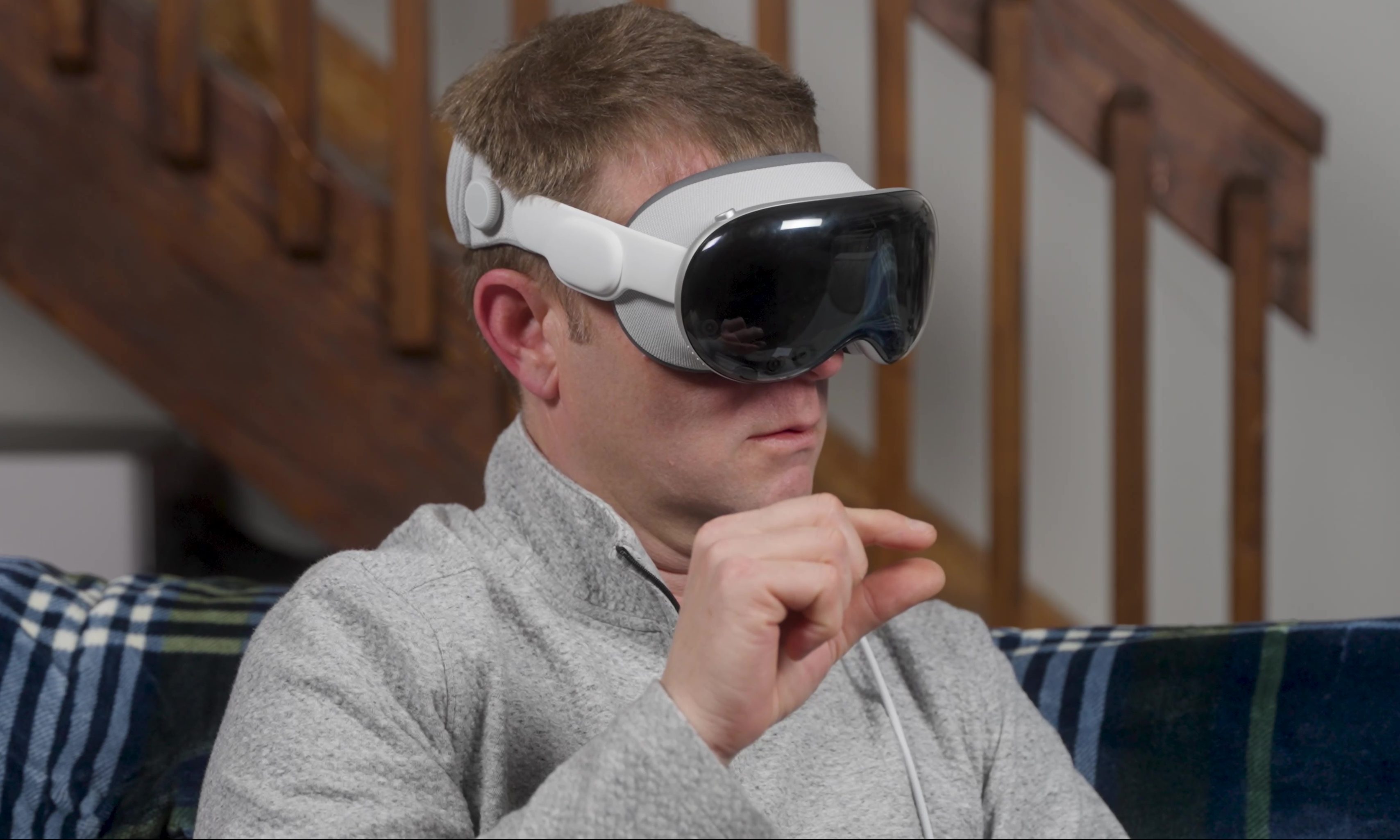 A person pinches while wearing an Apple Vision Pro.