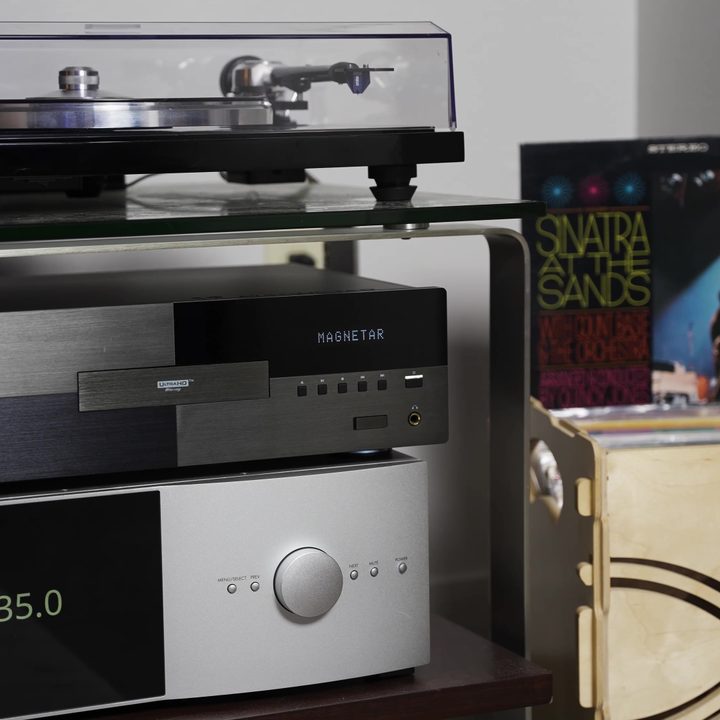 An AV gear rack with turntable, Mangetar receiver, and collection of vinyl records.