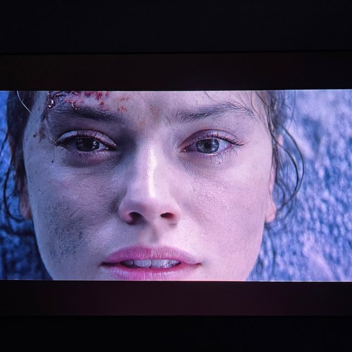 A scene from Star Wars:The Rise of Skywalker with Rey looking at the camera.
