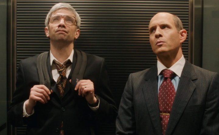 Two men stand in an elevator in BlackBerry.