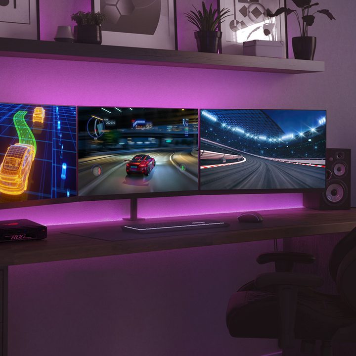 The Asus ROG NUC on a desk surrounded by three monitors.