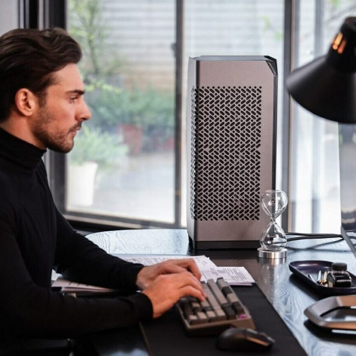 A person setting at a desk with the Cooler Master Ncore 100 Max case.