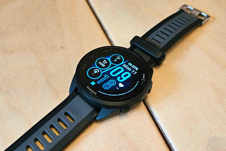 The Garmin Forerunner 165 Music laid on a wooden bench.