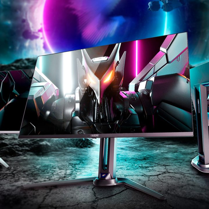 Three Gigabyte Aorus monitors over a colorful background.