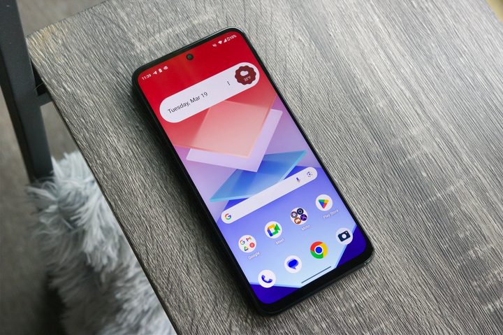 The Moto G Power 5G (2024) laying on a shelf, with its screen turned on.