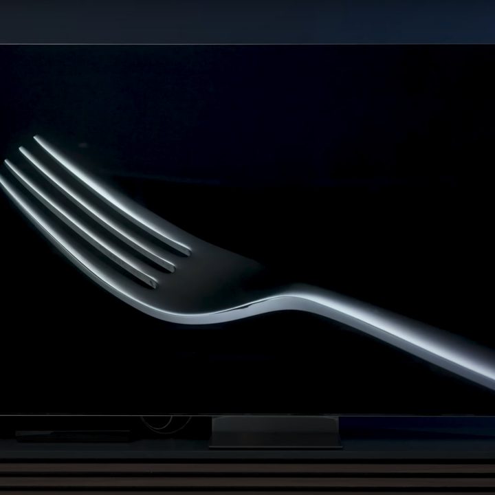 A closeup of a fork against a black background on a Samsung QN900D.