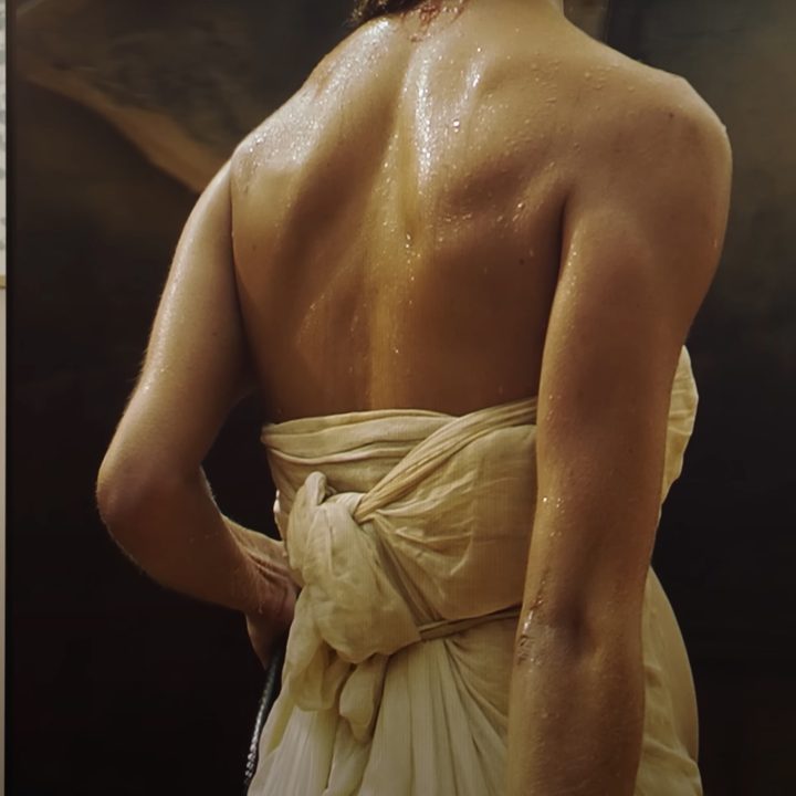A person's bare back is shown on a Samsung S95D OLED TV.