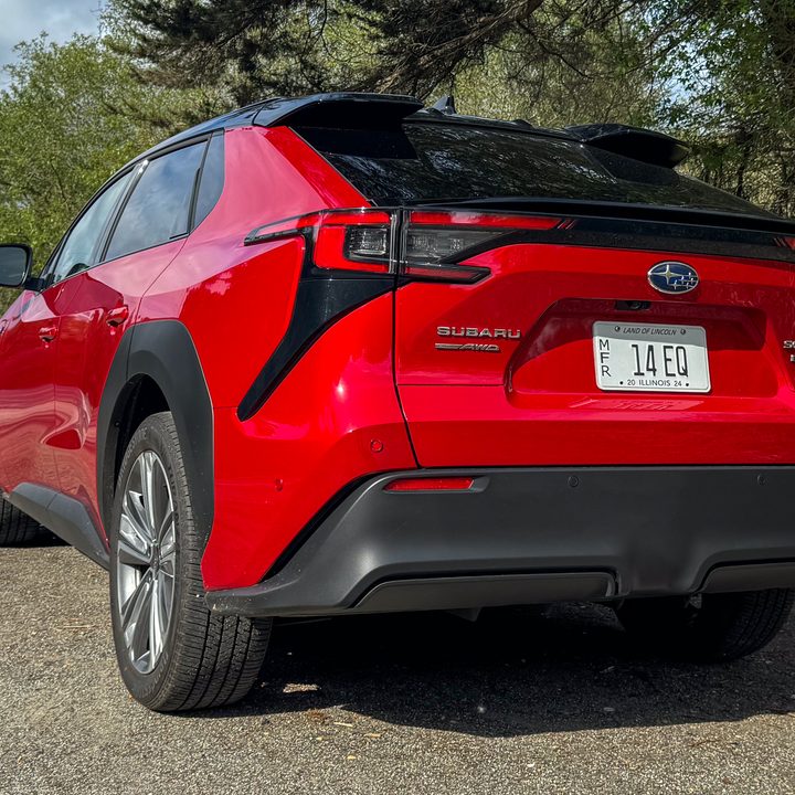 A rear three-quarters view of a red 2024 Subaru Solterra.