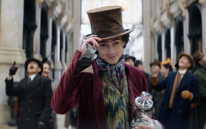 A man tips his hat in Wonka.