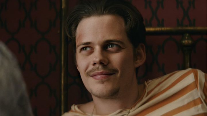 Bill Skarsg&aring;rd as Mickey smiling at someone off-camera in Villains.