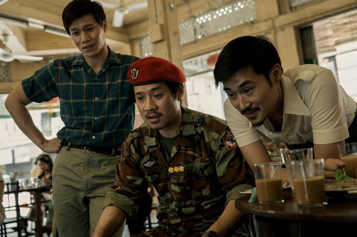 Hoa Xuande, Fred Nguyen Khan, and Duy Nguyen sit and stand together in The Sympathizer.