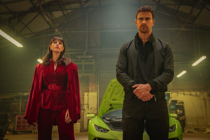 Kaya Scodelario stands next to Theo James in The Gentlemen.