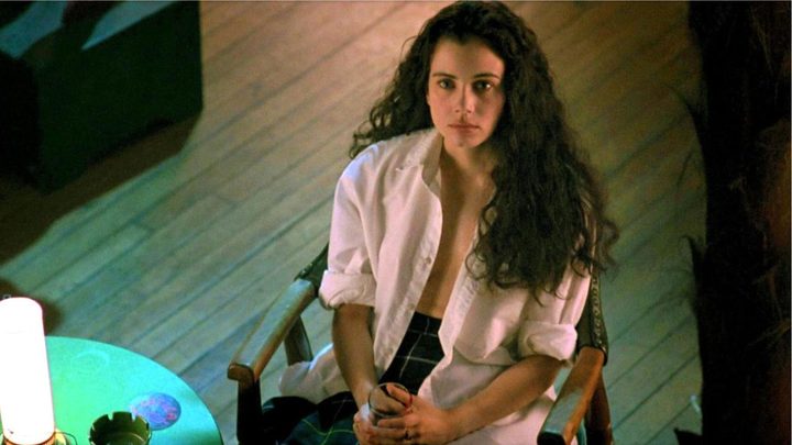 Mia Kirshner as Christina sitting down and looking up in the film Exotica.