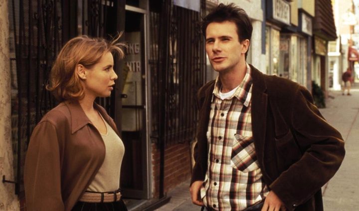 A woman and a man stand next to each other on a street.