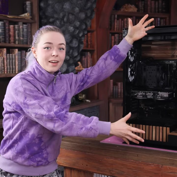 Martina of Nerdforge stands next to a custom gaming PC.