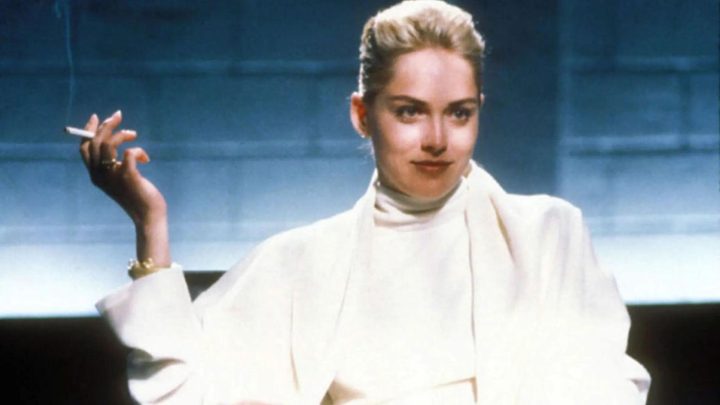 Sharon Stone as Catherine Tramell holding a cigarrette and smiling seductively in Basic Instinct.