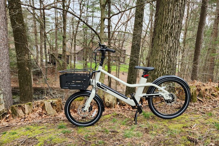 Vvolt Slice Lite left side profile with basket, parked on a hillside with trees in the background.