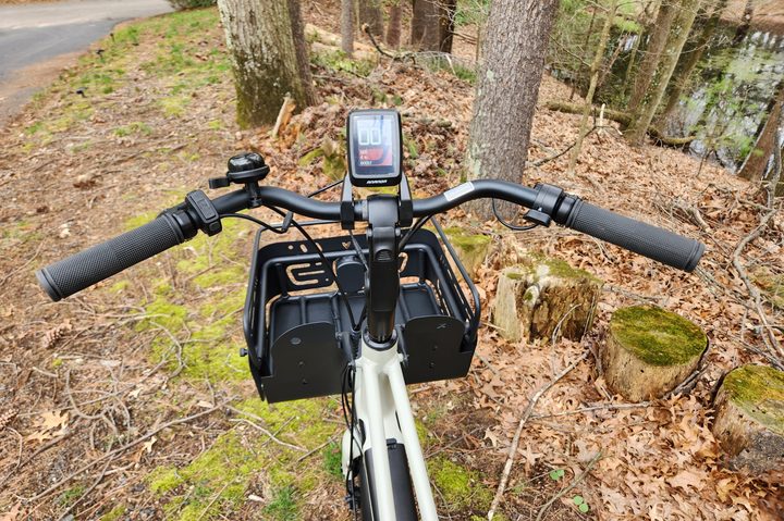 Vvolt Slice Lite rider's view of display screen, handlebars, bell, brakes, control panel, thumb throttle, and cargo basket.
