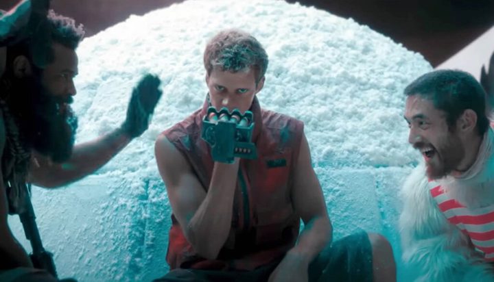 A man stares ahead as two guys laugh in Boy Kills World.