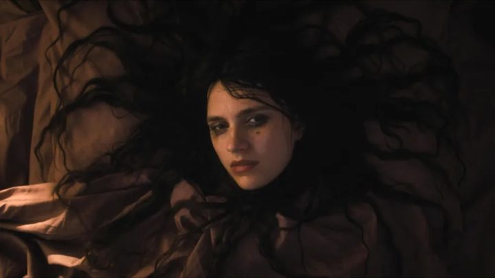 Nell Tiger Free with her hair spread out around her pillow in The First Omen