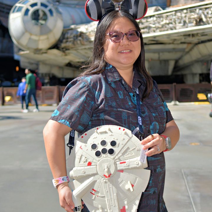Person holding Millennium Falcon in front of the Millennium Falcon.