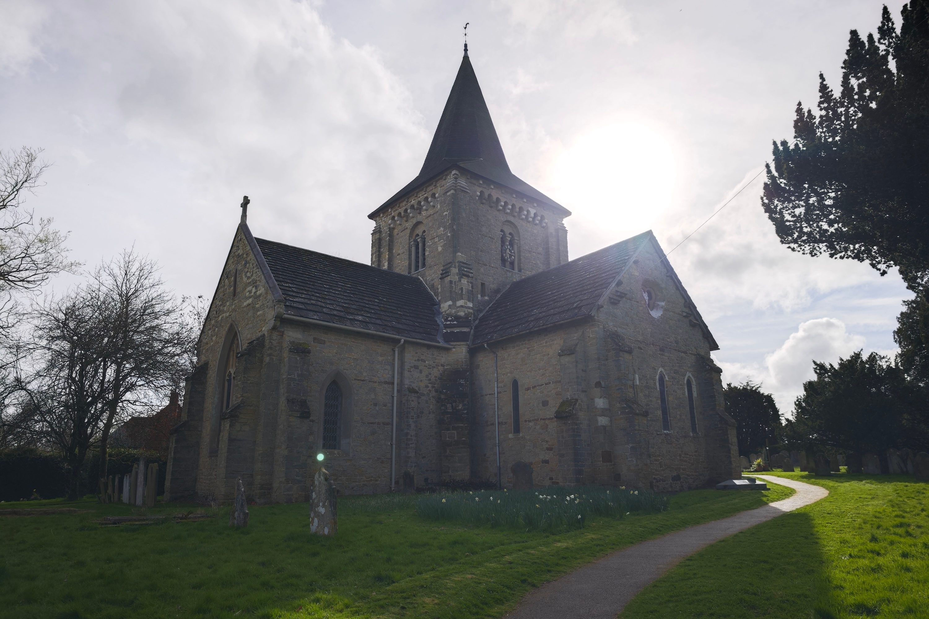 A photo of an orb floating over a gravestone in a churchyard.