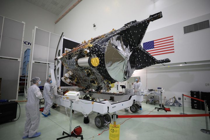 NASA’s Psyche spacecraft is shown in a clean room at the Astrotech Space Operations facility near the agency’s Kennedy Space Center in Florida on Dec. 8, 2022. DSOC’s gold-capped flight laser transceiver can be seen, near center, attached to the spacecraft.