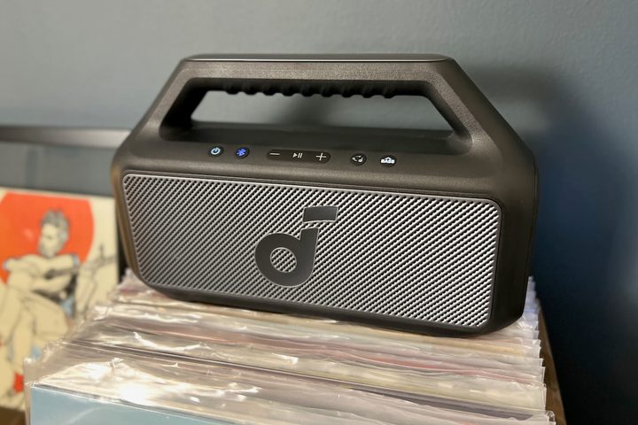The Soundcore Boom 2 Bluetooth speaker on top of a case of vinyl records.