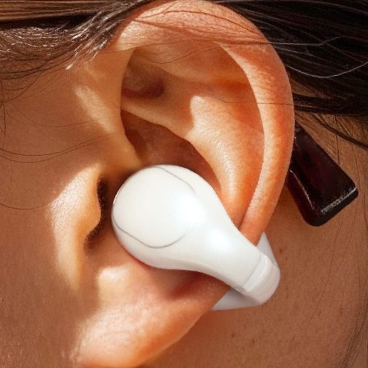Close up of someone wearing glasses and Soundcore C30i clip-style open earbuds.