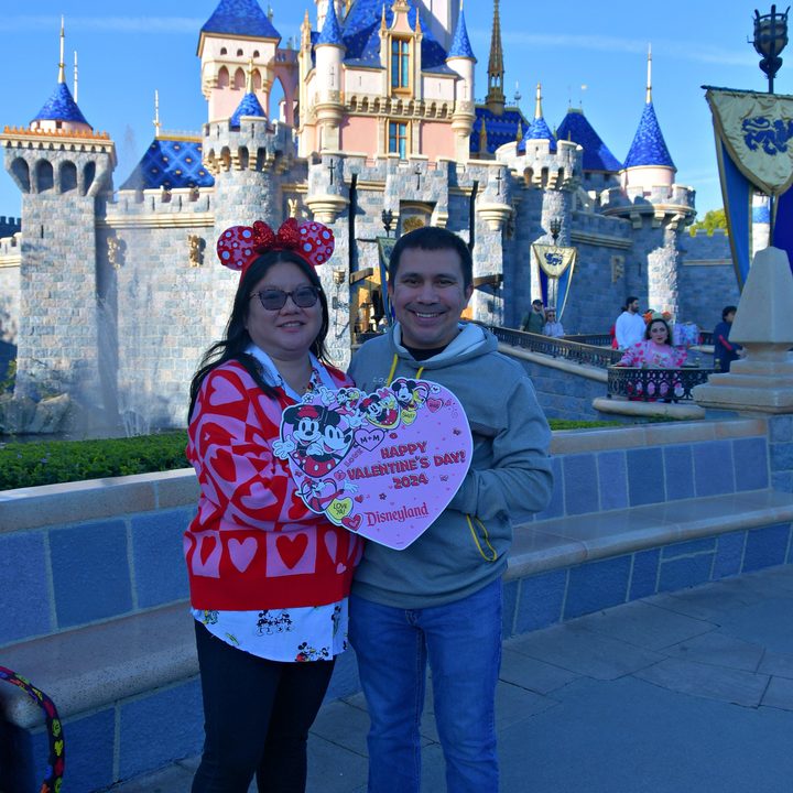 Couple in front of castle at Disneyland on Valentine's Day.