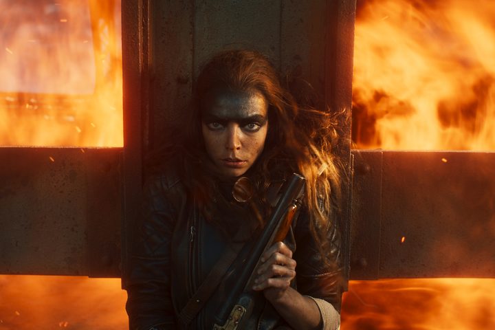 Anya Taylor-Joy shields herself from fire in Furiosa: A Mad Max Saga.