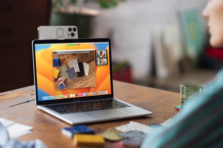An iPhone being used as a webcam on a MacBook thanks to Apple's Continuity Camera feature in macOS Ventura.