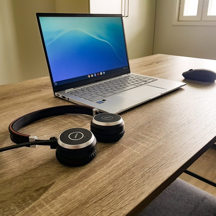 Chromebook on a table with a mouse and headphones