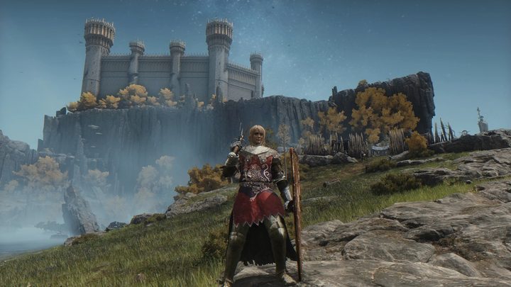 A female knight below a castle in Elden Ring.