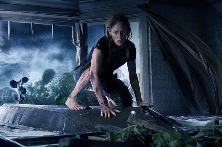 A girl stands on a table above water in Crawl.