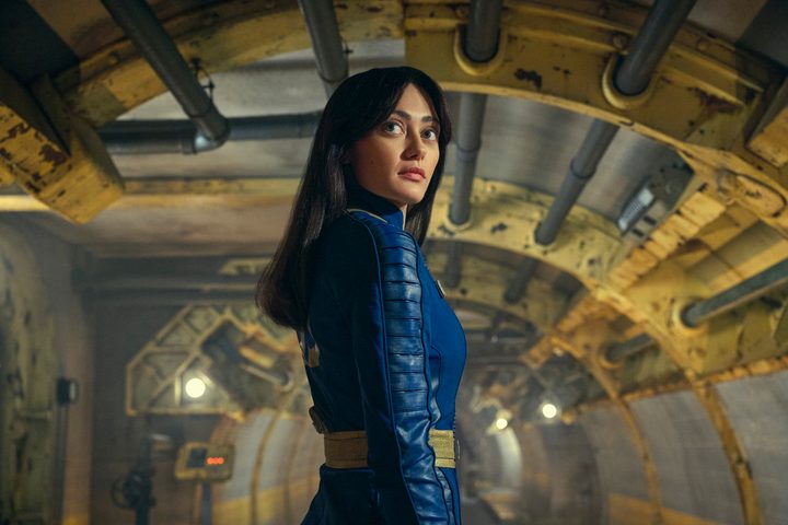 Lucy stands in a vault in Fallout.