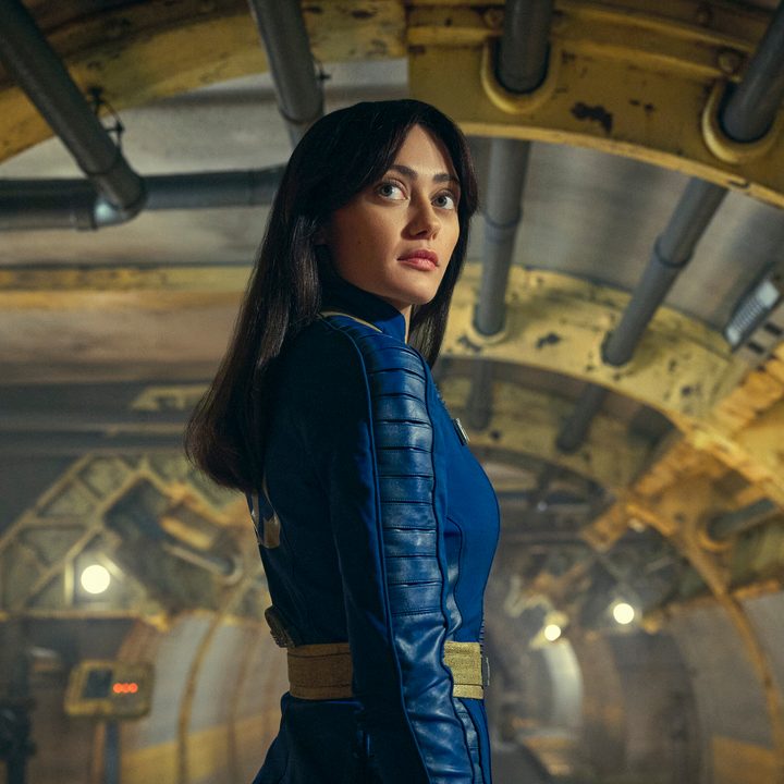 Lucy stands in a vault in Fallout.