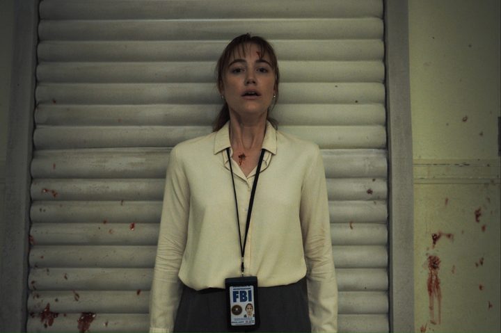 A woman stands against a wall with a scared look on her face in "Longlegs."