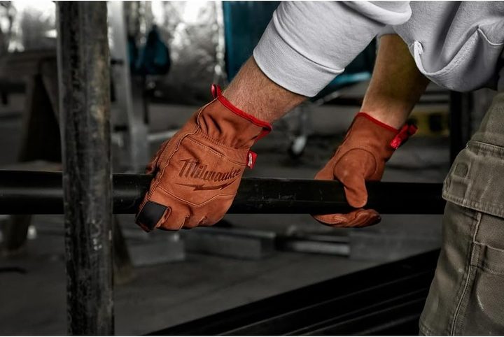 A man using Milwaukee Goatskin Leather Gloves for handling iron.