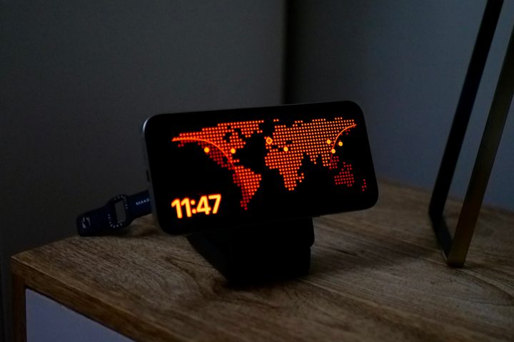 The iPhone 15 Pro Max with Standby mode in Night Mode on the Anker MagGo Wireless Charging Station.