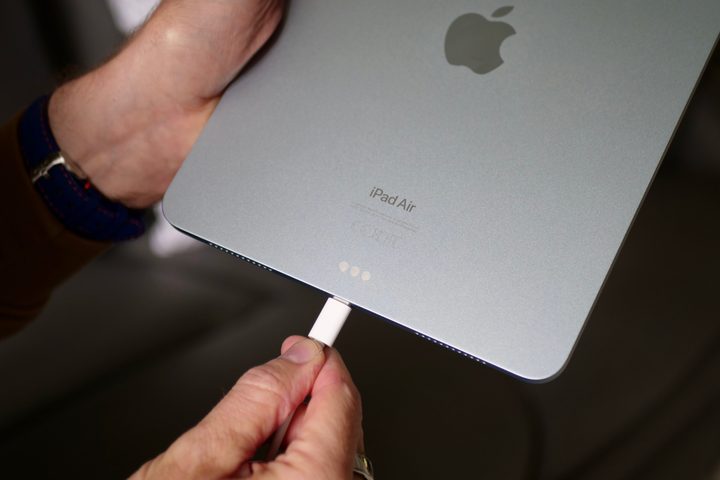 A person putting the Apple iPad Air (2024) on charge.