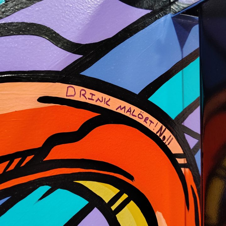 Writing on a colorful mural with purple, blue, and orange colors.