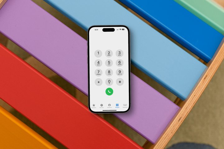 An iPhone on a colorful chair showing phone buttons.