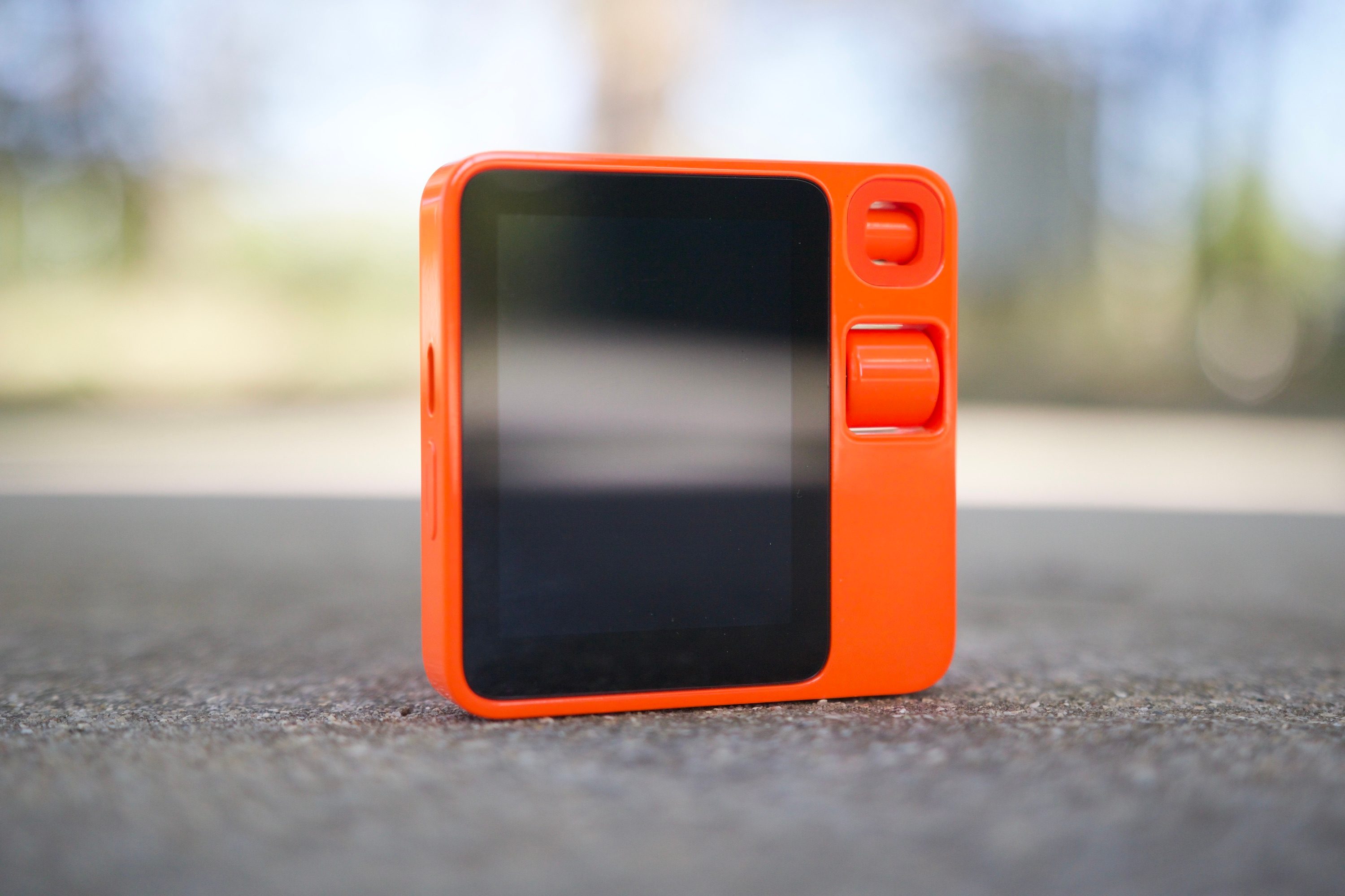 The Rabbit R1 sitting upright with its display turned off.