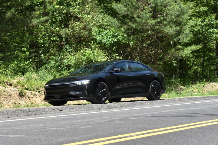 A black 2024 Lucid Air Grand Touring parked at the side of a road.