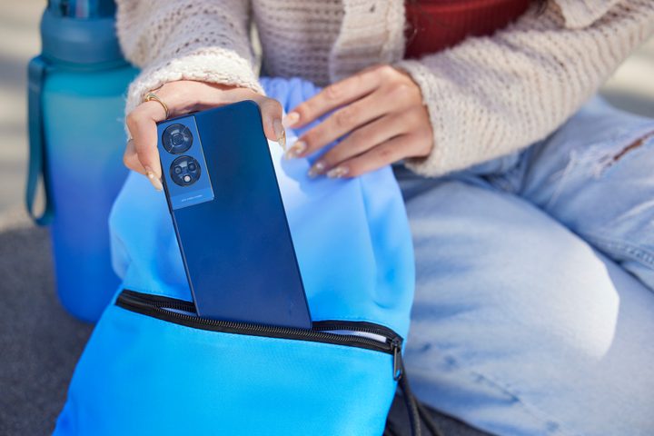 Someone taking a TCL 50 XE 5G smartphone out of a handbag.