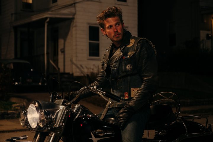 Austin Butler sits on a motorcycle at night in The Bikeriders.
