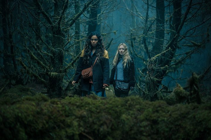 Georgina Campbell and Dakota Fanning walk through the woods together in The Watchers.