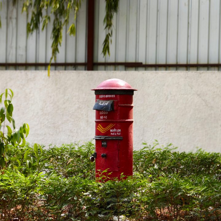 Red post box on a sidewalk on a street in New Delhi, India clicked using Vivo X Fold 3 Pro with Zeiss cameras.